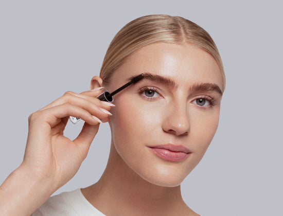 model applying hi-def brow gel in clear